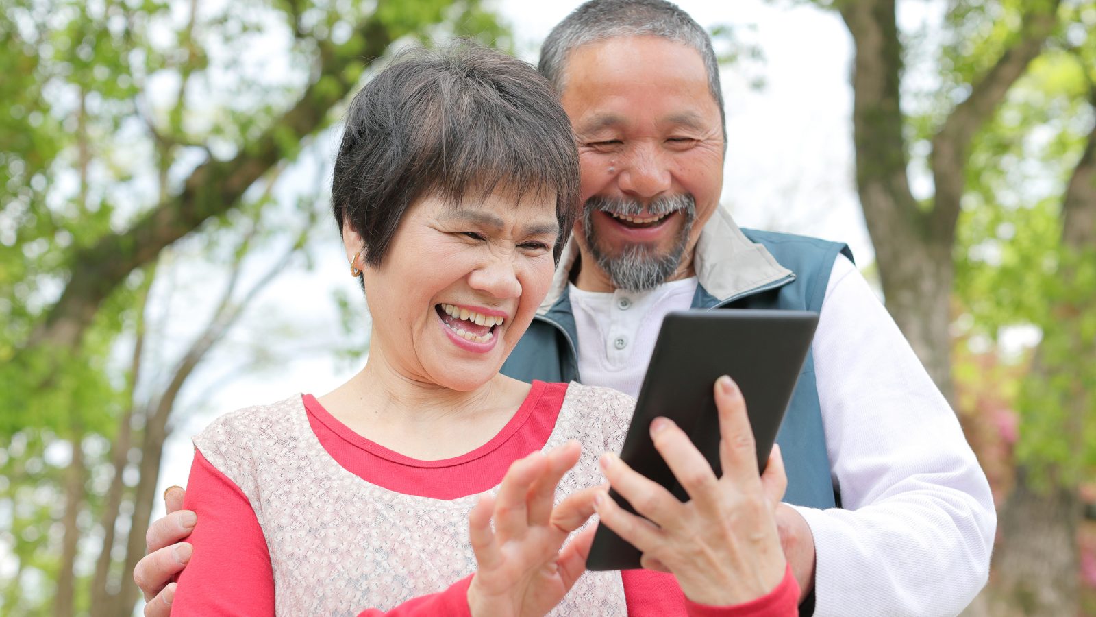スマートフォンを一緒に見て笑うシニアのご夫婦